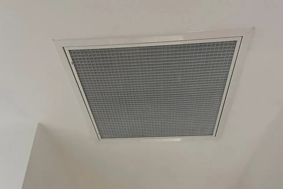 Grille de reprise blanche d’une climatisation gainable intégrée au plafond